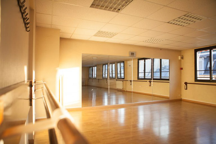 Salle 4 — parquet en bois, miroirs et barres, espace lumineux où ont lieu les cours West Vibes