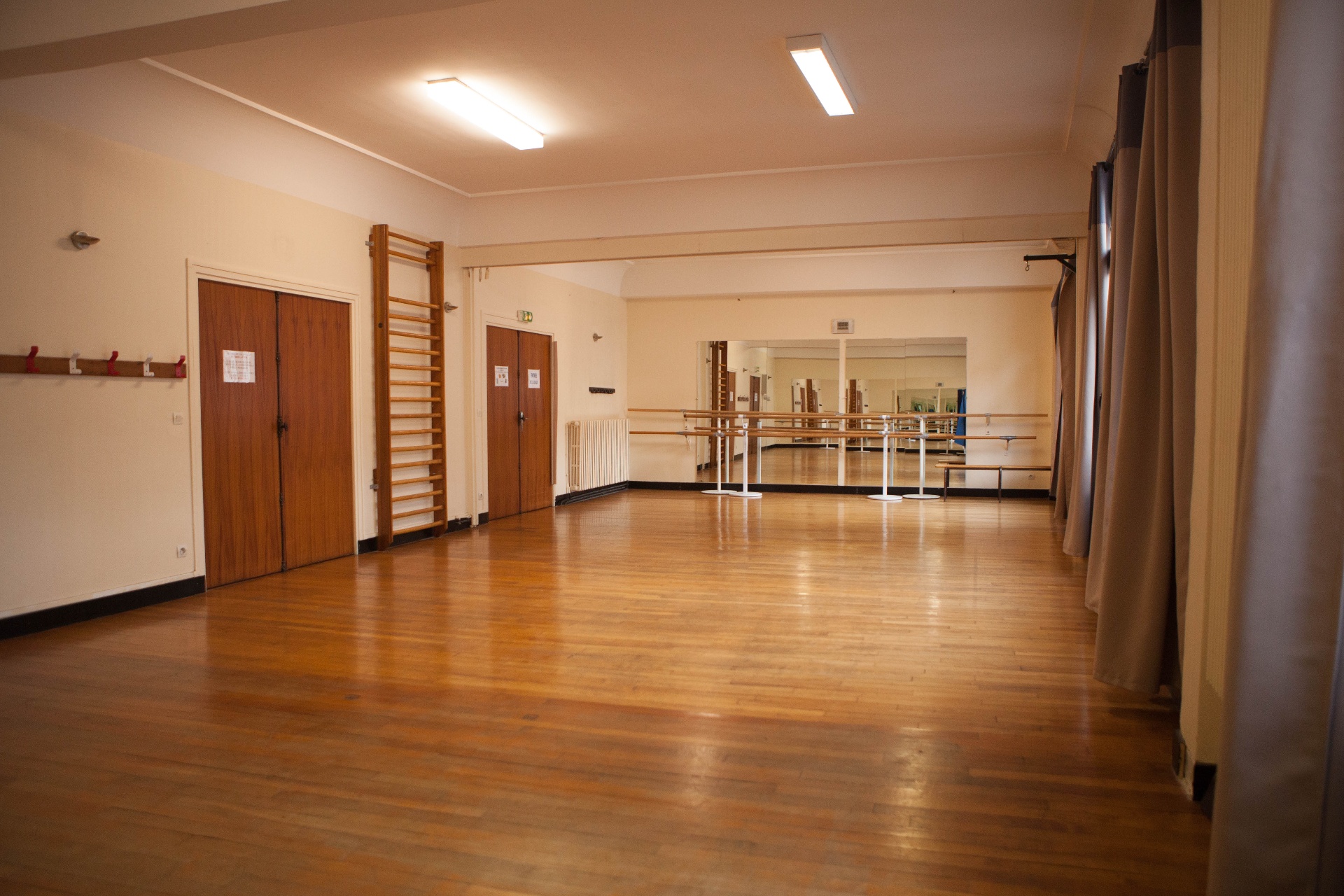 Salle 2 — parquet en bois, miroirs et barres, espace lumineux où ont lieu les cours West Vibes